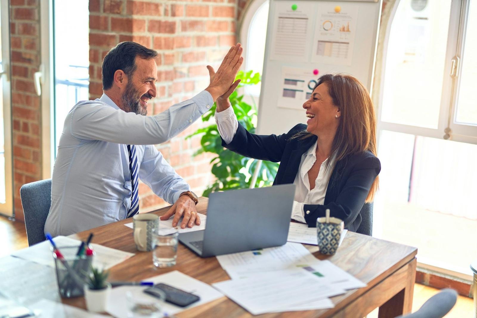 Two business professionals celebrating an agreement